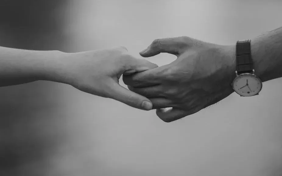 Two people reaching toward one another